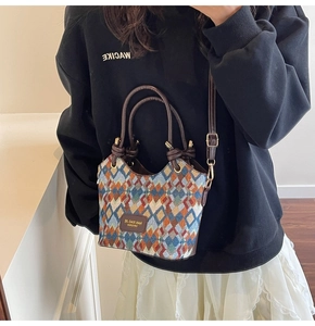Detail of colorful geometric lattice woven bucket bag with brown leather handles