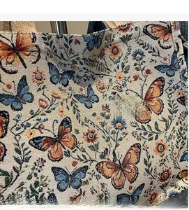 Detailed macro view of woven fabric featuring butterfly and floral patterns on a tote bag