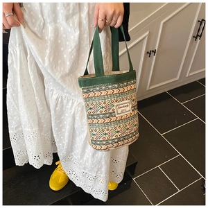 Détail du sac tissé géométrique coloré avec poignées en toile verte et étiquette blanche