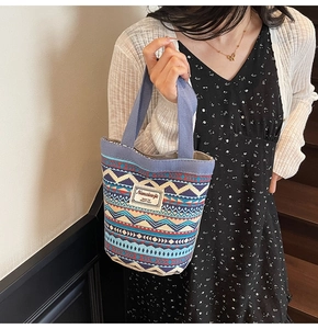 Detail view of ethnic canvas tote bag with blue geometric patterns and Nanxiaojie logo