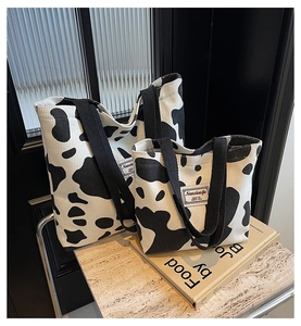 Detail of two cow print corduroy tote bags in large and small sizes with black straps