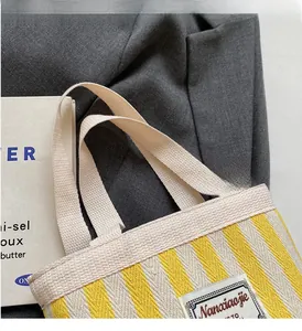 Detail of yellow and white striped canvas bucket bag with vintage logo label