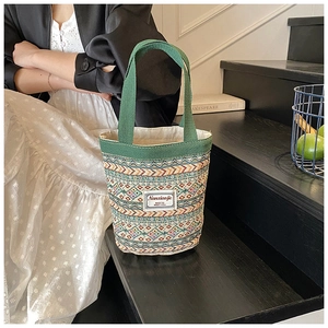 Détail d'un sac seau en lin aux motifs géométriques colorés avec poignée en tissu vert
