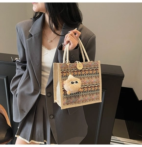Ethnic woven tote bag detail with colorful geometric patterns and plush monster charm