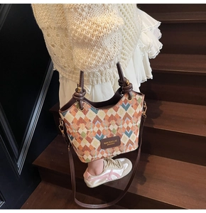 Detail of bohemian geometric woven bucket bag with leather handle and strap