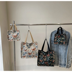 Detail showing jacquard butterfly floral tote bags in cream and black color variants
