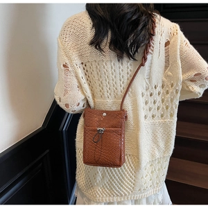 Detailed weave texture on brown crossbody phone bag with cute bear drawstring clasp