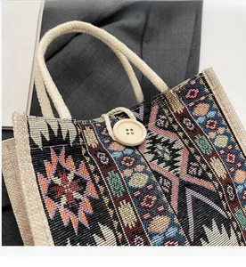 Detail of ethnic woven handbag with geometric patterns and large wooden button closure