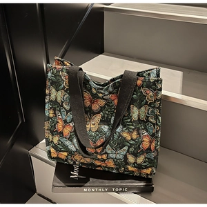 Close-up of colorful butterfly jacquard pattern on a dark green tote shopping bag