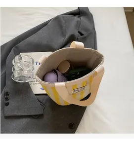 Detail showing the spacious interior of yellow striped canvas tote bag with essentials