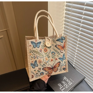 Detail of linen lunch bag with butterfly prints and large wooden button closure