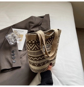 Detail of retro geometric print canvas bucket bag with vintage ethnic patterns on a bed