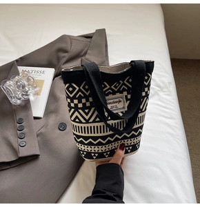 Detailed close-up of a canvas bucket bag with ethnic geometric patterns and hand straps