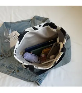 Spacious interior of cow print corduroy tote bag showing various daily essentials inside