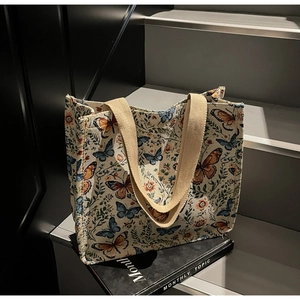 Detail of floral butterfly jacquard fabric and woven handles on a large tote bag