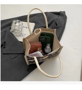 Spacious interior of ethnic embroidered tote bag showing phones, wallet and cosmetics