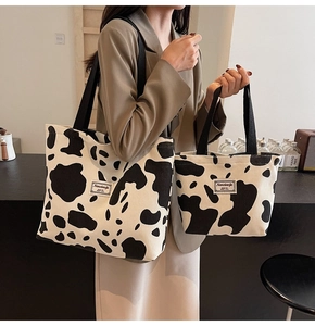 Detail of cow print corduroy tote bags in two sizes with stitched text labels