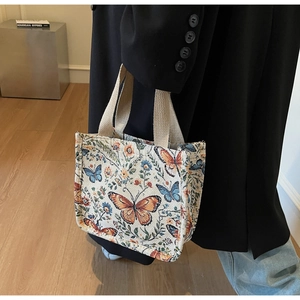 Detailed texture of jacquard fabric with colorful butterfly embroidery on a tote bag