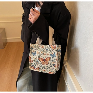 Detail of vintage knit jacquard tote bag with butterfly floral pattern and woven handles