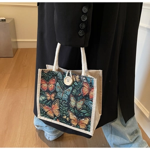 Detail of canvas lunch bag with butterfly patterns and natural wooden button closure
