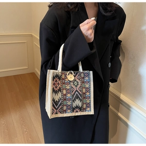 Detail of bohemian jacquard handbag with geometric patterns and a wooden button closure