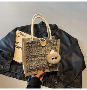 Detail of linen tote with colorful geometric patterns and decorative plush charm