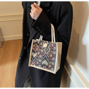 Close-up of ethnic jacquard fabric mini tote with cotton rope handles and wood button