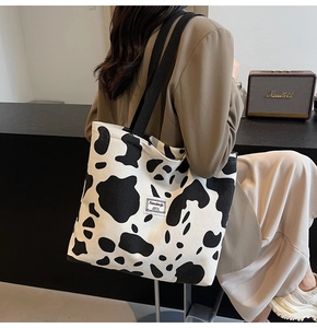 Detail of corduroy tote bag with cow print pattern and stylish brand label patch