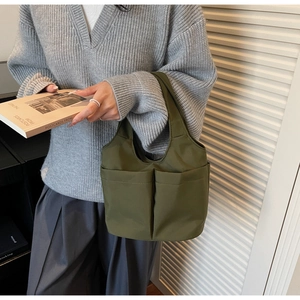 Dettaglio di una borsa hobo oversize in tessuto verde oliva con ampie tasche casual