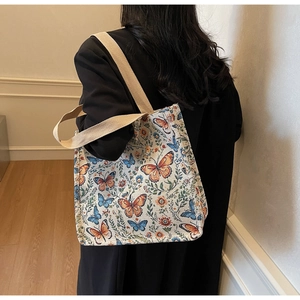 Detail of floral jacquard tote bag featuring colorful butterfly patterns and canvas straps