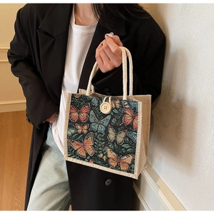 Detail of butterfly tapestry bag with wood button closure and rope handles