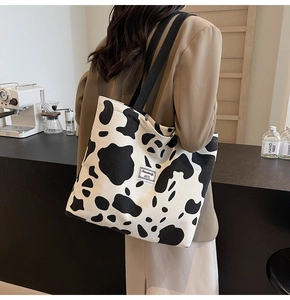 Close-up of cow print corduroy tote bag featuring large capacity and soft texture
