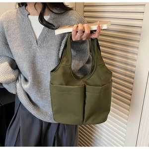 Borsa a secchiello verde oliva in tela con doppie tasche ampie mostrata in una vista lifestyle