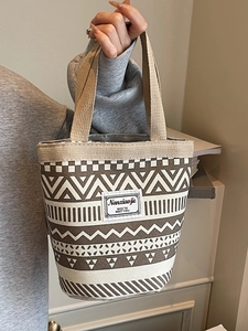 Ethnic style geometric canvas bucket bag with woven handles and minimalist print pattern