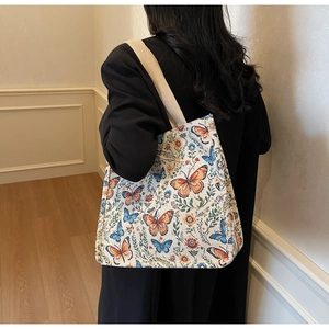 Close-up of brocade tote bag with vintage butterfly pattern and wide cotton strap