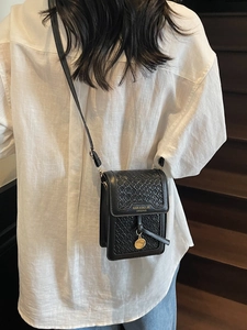 Fashionable black woven crossbody bag for women with adjustable leather strap and gold tag