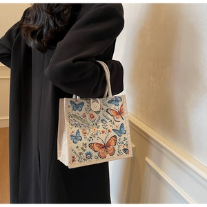 Detail of floral tapestry linen tote bag with cream rope handles and button closure