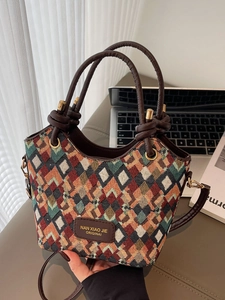 Quilted geometric pattern bucket bag with brown leather handles and gold metal hardware