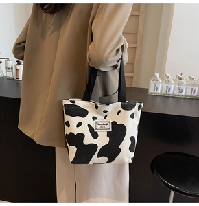 Detail of cow print corduroy tote bag showing thick texture and sturdy black straps