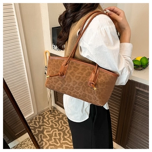 Close-up of leopard pattern texture and embossed brand logo on large brown tote bag