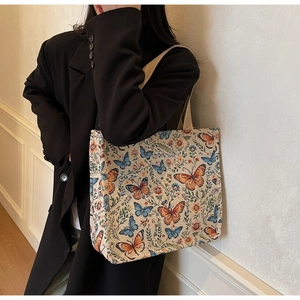 Detailed view of a large tote bag featuring colorful vintage floral and butterfly patterns