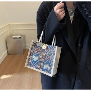 Detailed view of ethnic woven handbag with blue geometric patterns and wooden button
