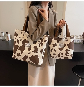 Detail of a large capacity tote bag set with brown cow print and corduroy texture