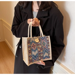 Detail of ethnic woven tote bag featuring geometric patterns and wooden button closure