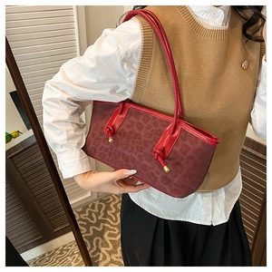 Detail of red leopard print canvas tote featuring red leather trim and gold metal sphere