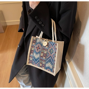 Detail of ethnic tote bag with blue geometric weaving, cotton rope handle and wood button