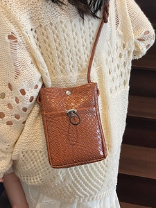 Chic brown woven crossbody phone bag for women styled with vintage knitwear