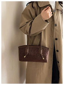 Detail of leopard print tote bag featuring a knotted leather strap and golden hardware