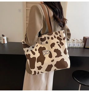 Detail of cow print corduroy tote bag showing large capacity and soft texture on shoulder