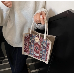 Detailed close-up of ethnic woven handbag featuring colorful geometric patterns and wood button